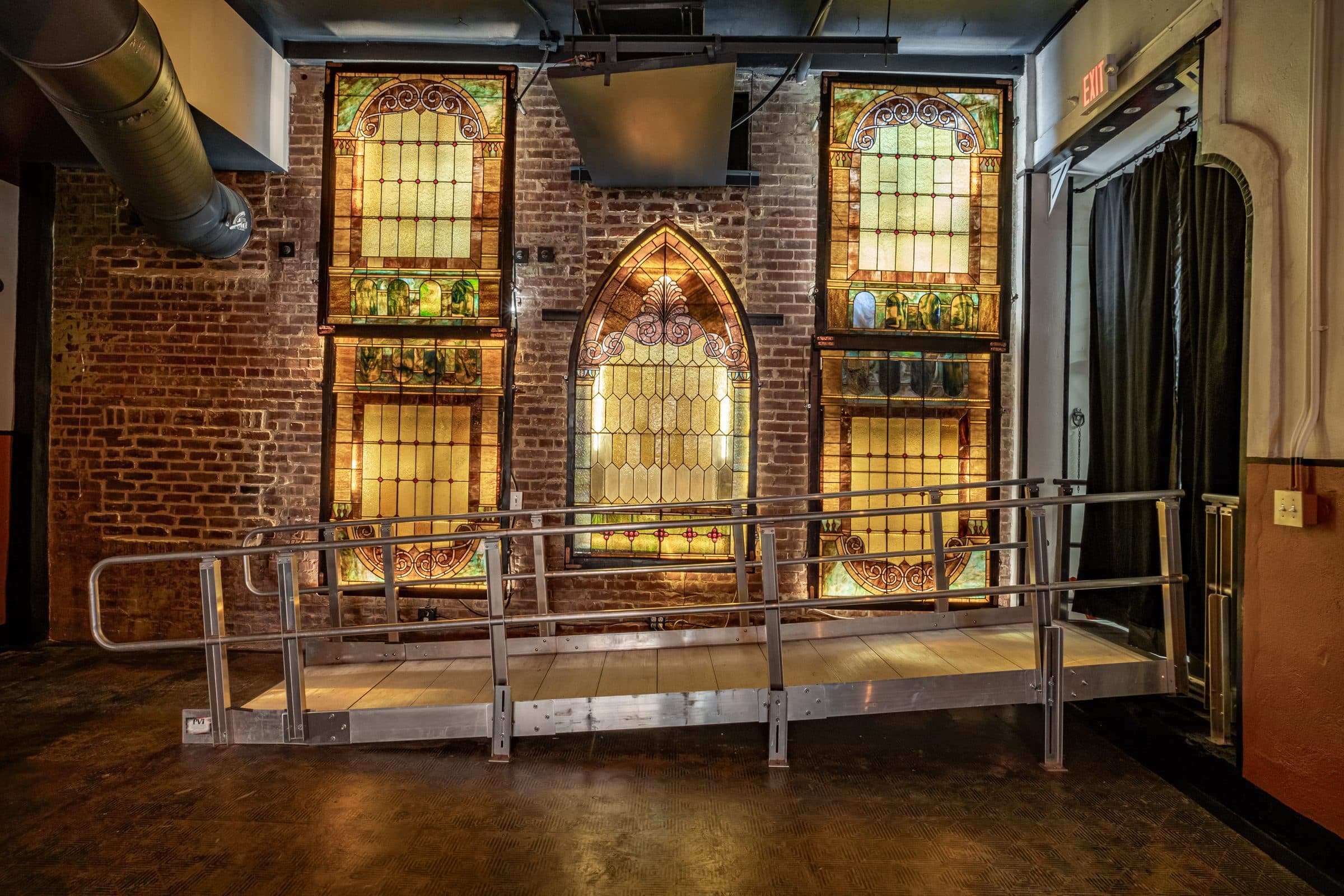 Stained-glass windows glowing behind the stage in the main hall