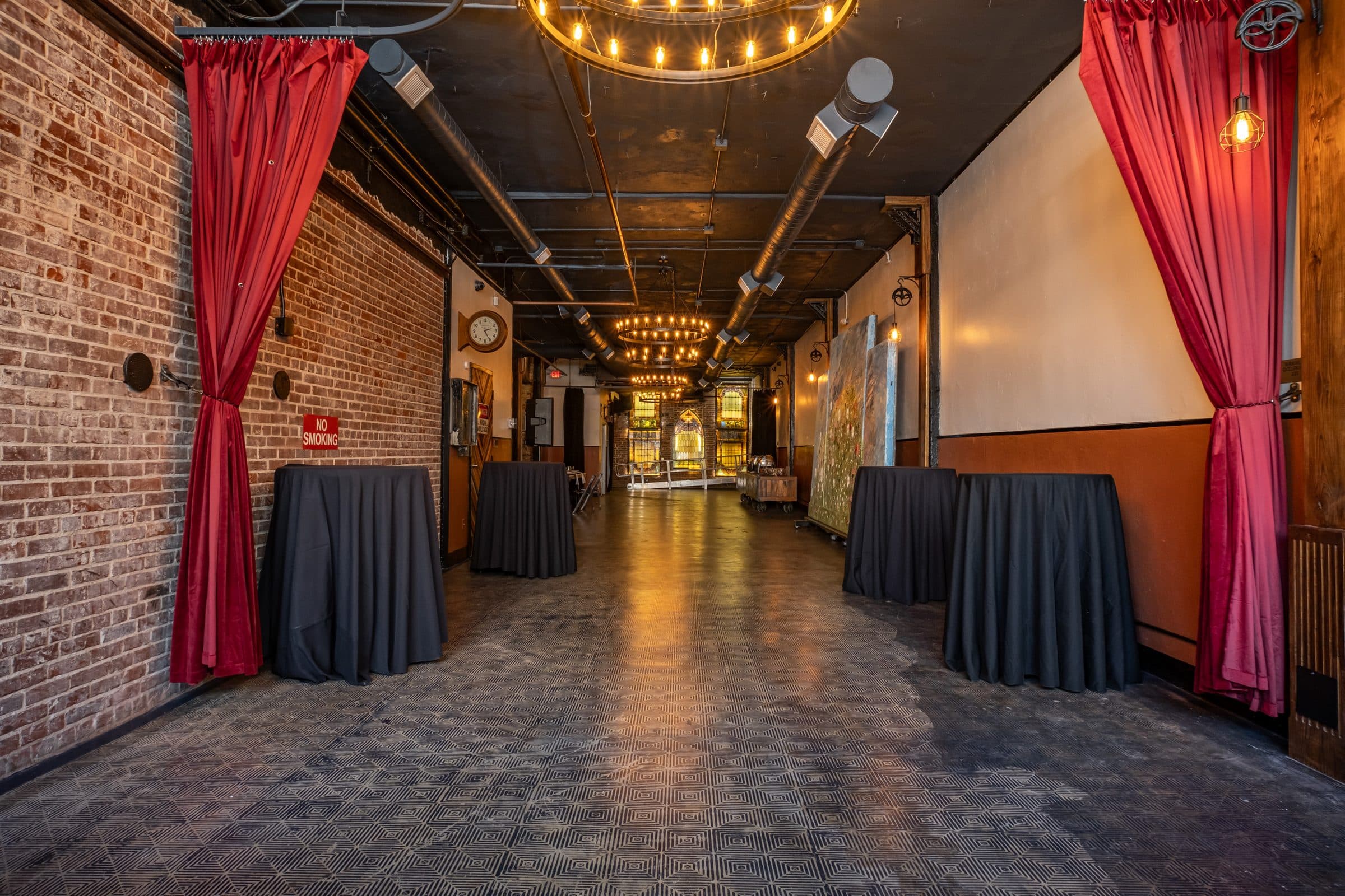 Cocktail tables between garnet curtains in the main hall