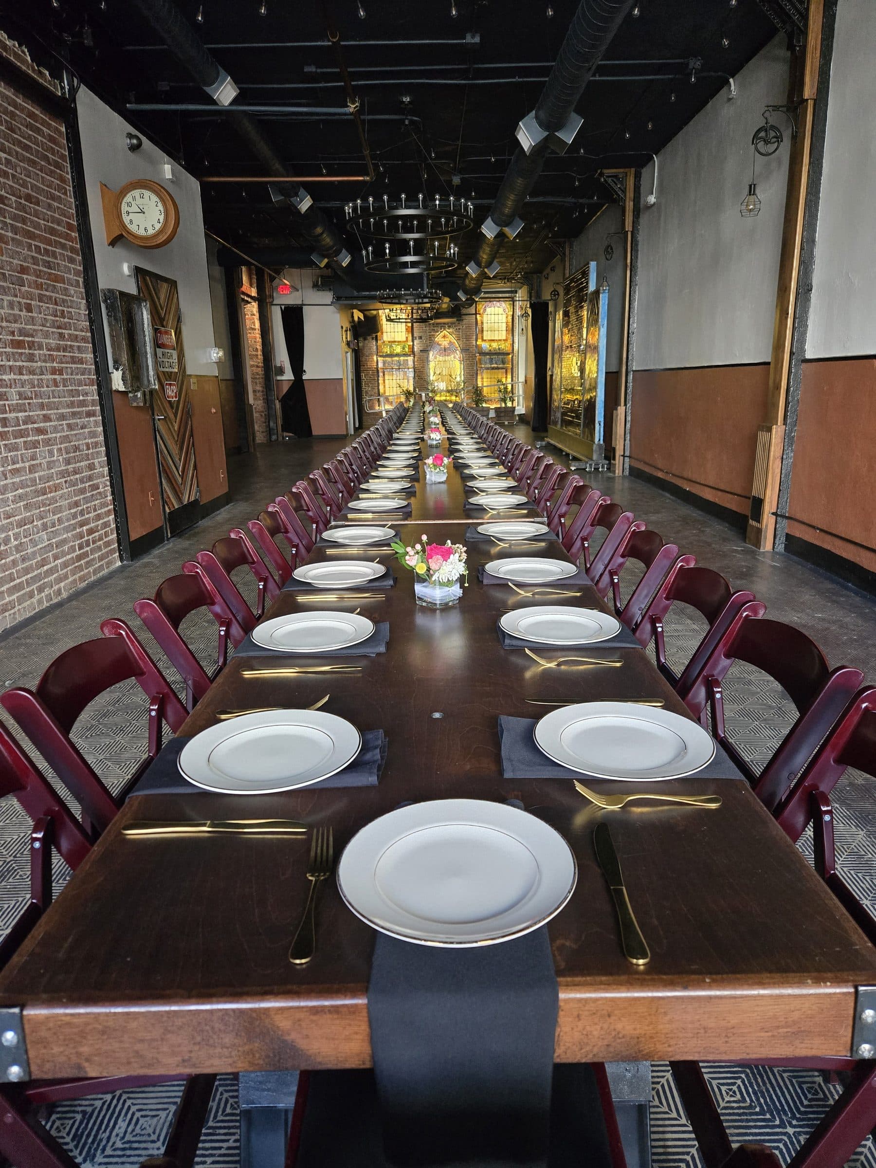 Long estate table set with white plates down the length of the hall
