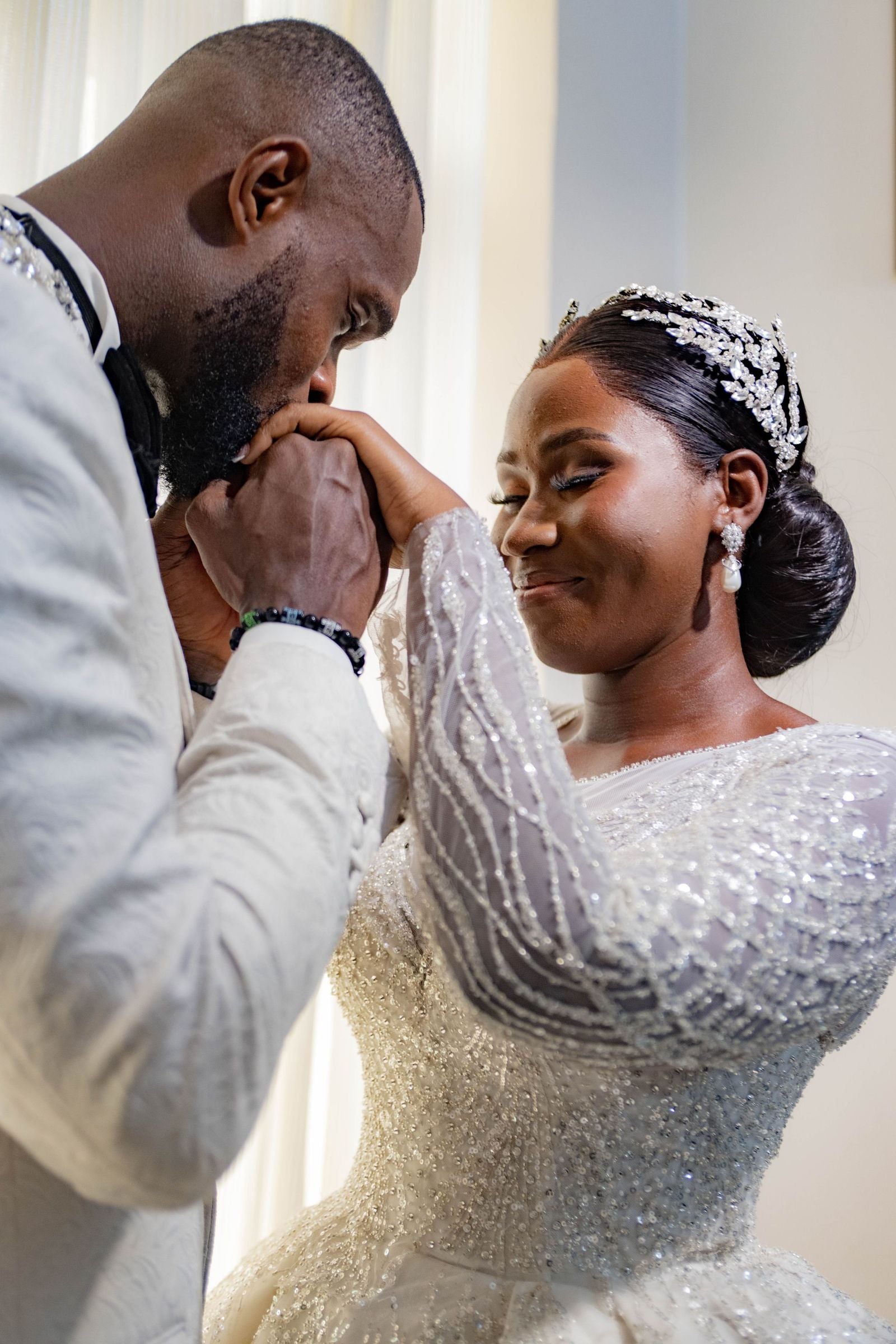 Groom kissing his bride’s hand on their wedding day