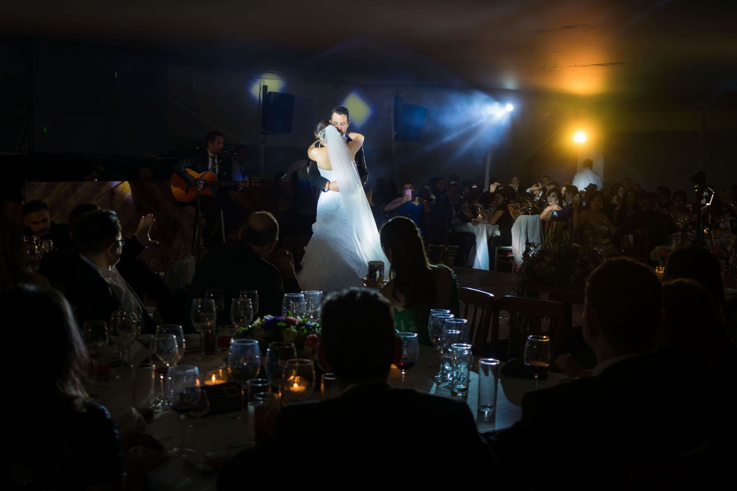 Couple dancing on stage at a candlelit wedding reception